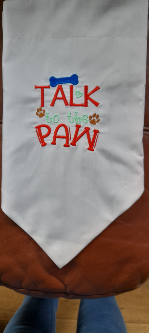 a doggy bandana saying talk to the paw